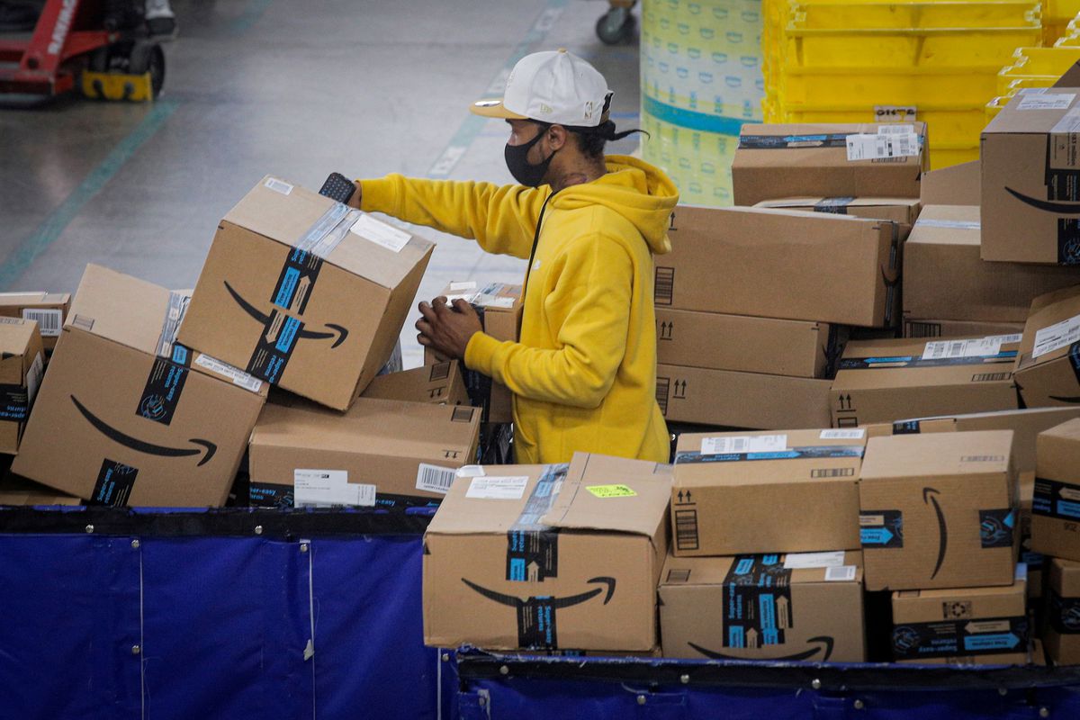 Worker sorting through Amazon boxes at a warehouse